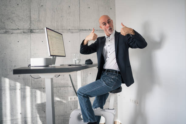 istock man enjoying adjustable height desk and bicycle in home office 2131917600