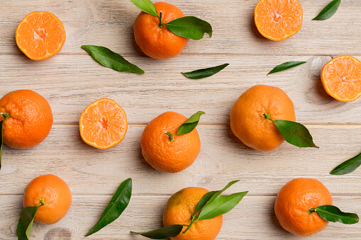 Many fresh ripe mandarin as colored background, top view. Elegant background of clementines and mandarin slices Top view flat lay.