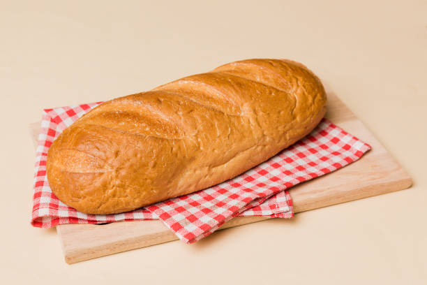 istock Freshly baked bread on cutting board against white wooden background. perspective view bread with copy space 2131929497