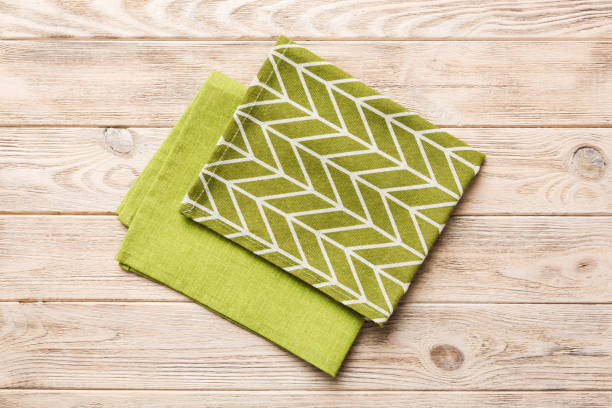 istock top view with green kitchen napkin isolated on table background. Folded cloth for mockup with copy space, Flat lay. Minimal style 2131930046