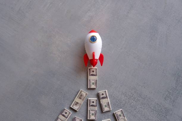 Rocket blasts off through a pile of money.