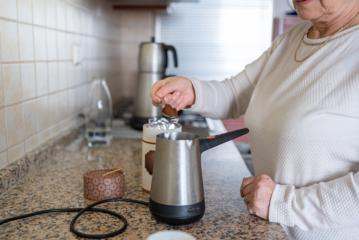 Senior Woman Making Turkish Coffee At Home