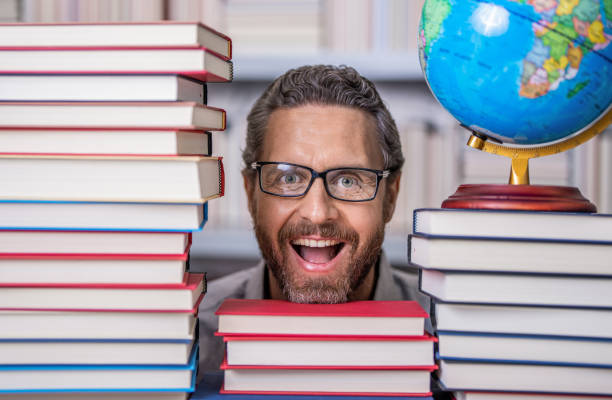 istock Tutor at classroom. Man geographer with books in classroom. Knowledge and education concept. school teacher with book in classroom. teacher in classroom. Teachers Day. endless possibilities 2131975745