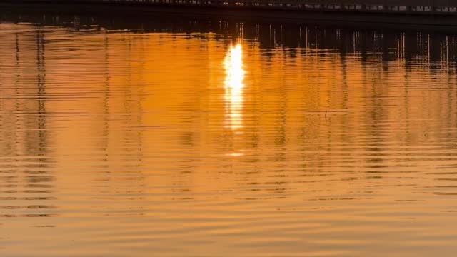 The reflection of the sunset in the evening lake water