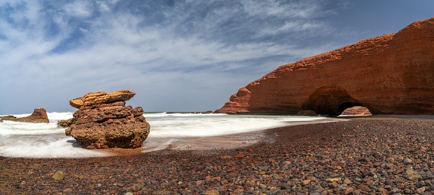 A panorama landscape view of the beach and rock arch at Legzira on the Atlantic Coast of Morocco