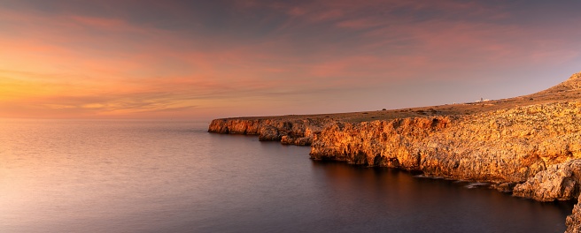 panorama landscape view of cliffs and rugged shorelina at Pont d'en Gil in northeastern Menorca near Ciutadella at sunset