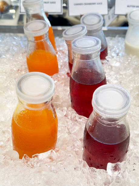 istock Full frame image of metal tray filled with chilled cold fruit juices drinks surrounded by ice cubes, crushed ice and screw top bottles of milk, orange and cranberry juices, non-alcoholic drinks in glass bottles covered in condensation, elevated view 2132084341