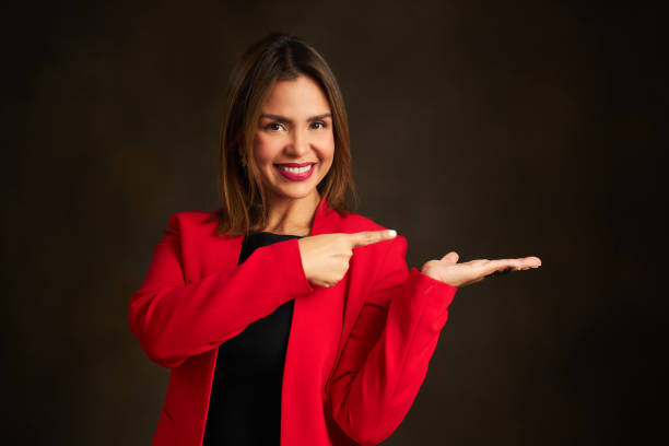 istock A woman in a red jacket points to the camera 2132105936