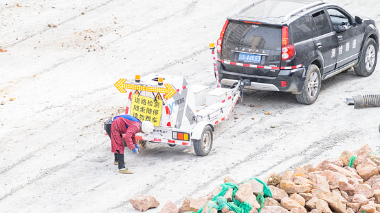 On a sunny day on February 19, 2024, an elderly woman cleaned up behind a road inspection vehicle in Shuangliu District, Chengdu City, Sichuan Province