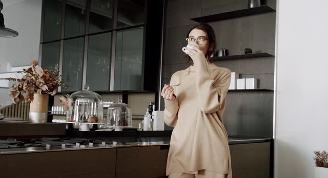 A beautiful Young woman is drinking tea cup in the modern kitchen room at home