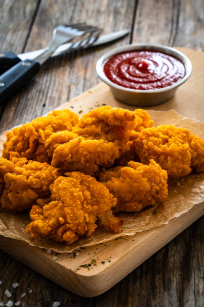 istock Fried chicken nuggets and ketchup on wooden background 2132128187