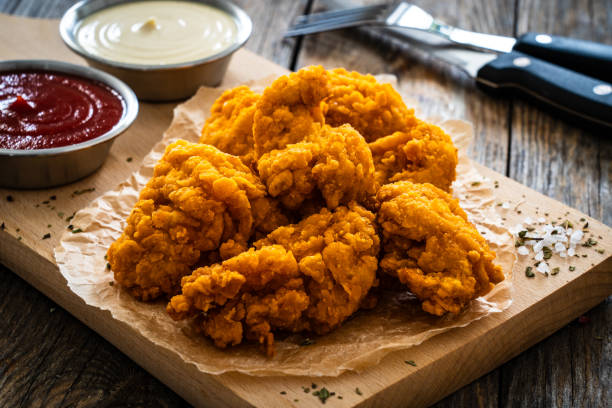 istock Fried chicken nuggets and ketchup on wooden background 2132128286