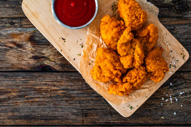 istock Fried chicken nuggets and ketchup on wooden background 2132129744