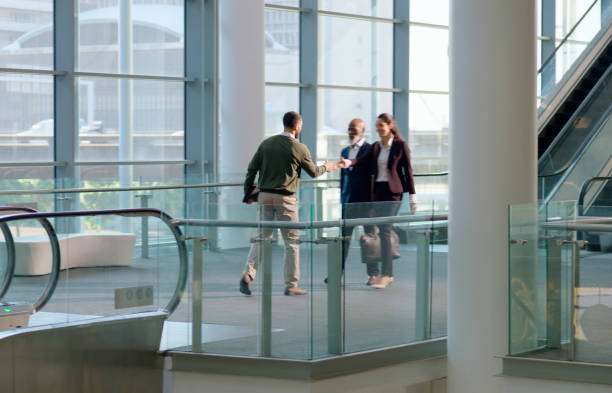 istock Business people, handshake or walking in corridor at work or communication as introduction or greeting. Man, woman and professional with shaking hands for meeting and onboarding on corporate project 2132136542