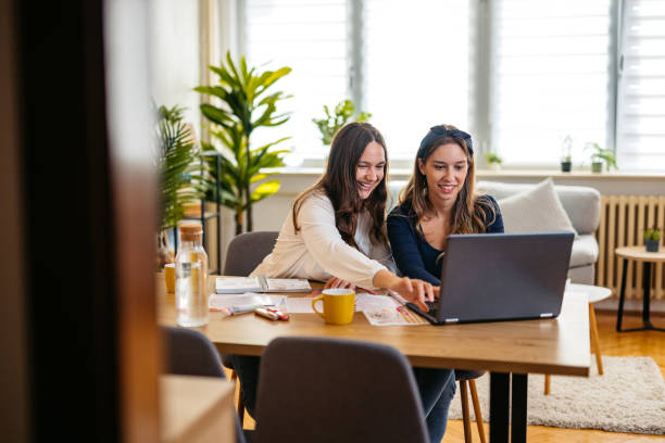 istock Two Female Friends Studying Together Using A Laptop At The Kitchen Table 2132139185