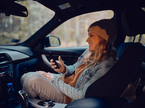 istock Happy woman using mobile phone in a car. 2132141805