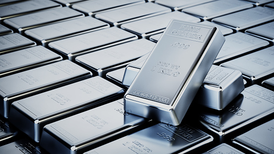 Multiple one-kilo silver bars are neatly arranged, showcasing their shine and texture, reflecting wealth, stability, and precious metal investment. The stamped inscriptions indicate purity and weight, highlighting the bars as a form of tangible asset.