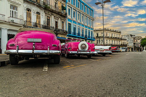 Bright retro cars on Havana street near the hotel. Cuba. Gran Teatro de La Habana, Low angle.
