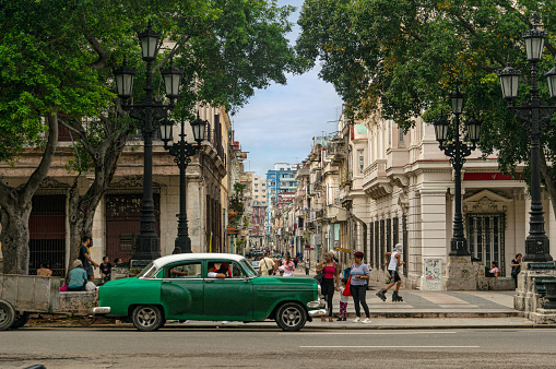 The Prado Boulevard is one of the main streets of Havana. Intersection, retro car, people walking.