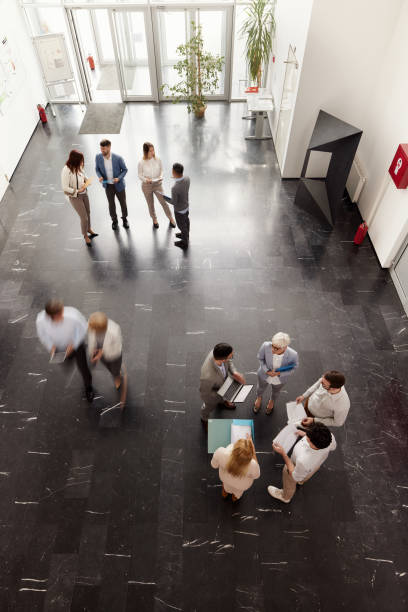 istock Above view of multi-tasking business people in a hallway. 2132150295