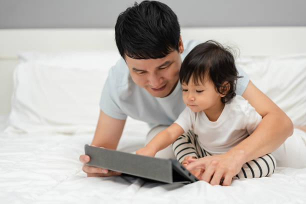 istock toddler baby with father using digital tablet pc on bed 2132152451