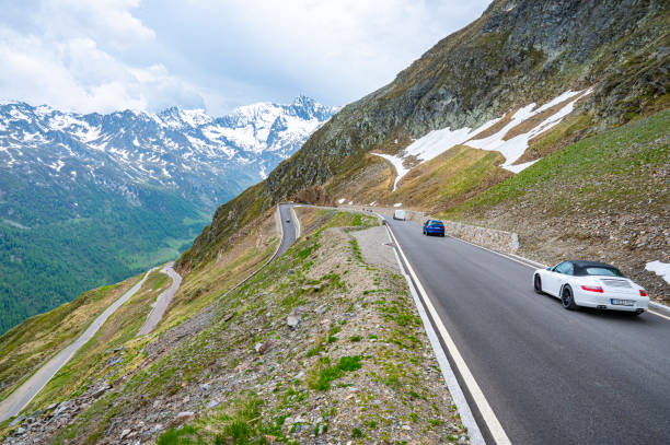 porsche 911 cabriolet sports car driving on an alpine road - ferrari italian culture porsche porsche 911 imagens e fotografias de stock