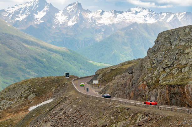 porsche 911 sports cars driving on an alpine road in the mountains - ferrari italian culture porsche porsche 911 imagens e fotografias de stock