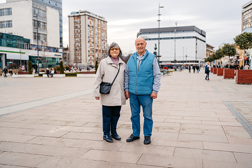 Portrait of a beautiful senior couple standing on the city street in winter.