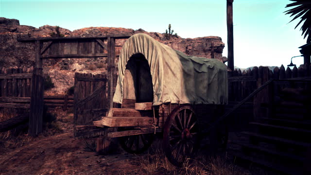 A vintage covered wagon in a rustic countryside setting