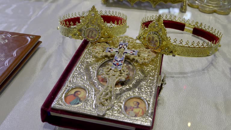 Golden Crowns On Antique Holy Bible In The Altar During Wedding Ceremony At Saint Nectarios Basilica In Lasi, Romania.