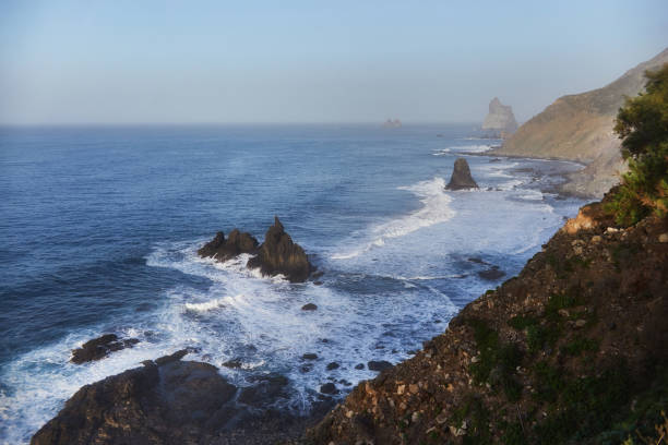 istock Dawn breaks over a tranquil coast with rocky cliffs and undulating waves, creating a peaceful seascape 2132267754