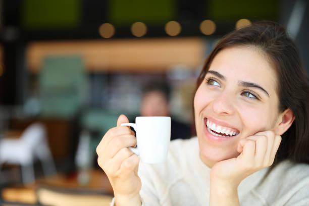 istock Happy woman with perfect teeth dreaming and drinking coffee 2132271432
