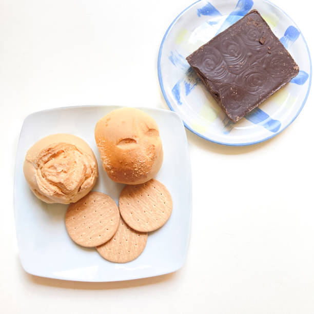 View of sweet snack at home in the kitchen table with cookies,sweet small bread , black coffee cup and dark chocolate tablet.