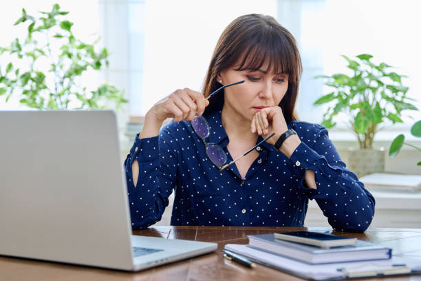 istock Tired sad mature woman at workplace at table with computer laptop 2132307657