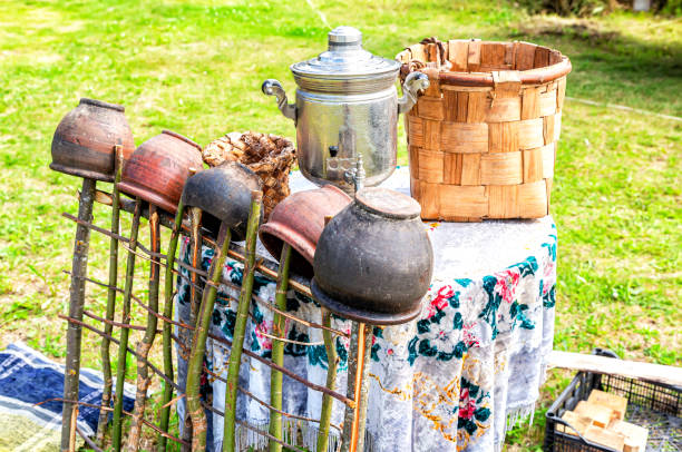 Vintage wicker handmade basket, samovar and utensils of pottery on table Vintage wicker handmade basket, samovar and utensils of pottery on table outdoors in summer unusual basket stock pictures, royalty-free photos & images