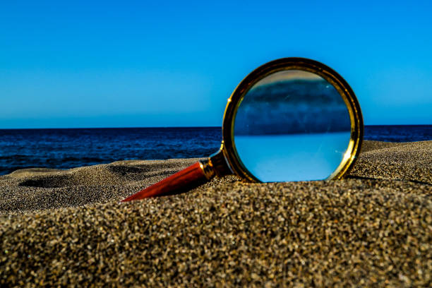 istock Magnify Glass on the Sand Beach 2132342250