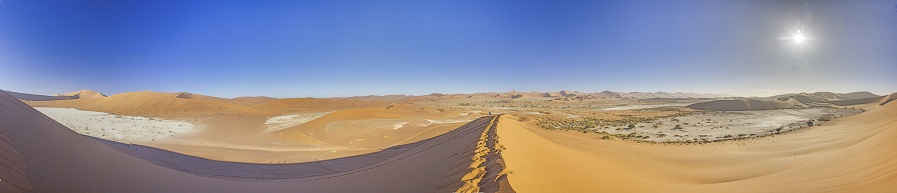Panoramic view from the Big Daddy Dune in Sussusvlei onto the salt pan of Deathvlei with surrounding red dunes in the morning in summer