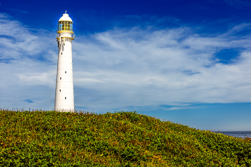 Slangkop Lighthouse guarding the shoreline in the beautiful Village of Kommetjie, Cape Town, South Africa.