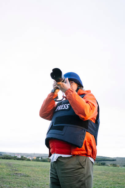 istock Reporter in bulletproof vest holding a camera. 2132420692
