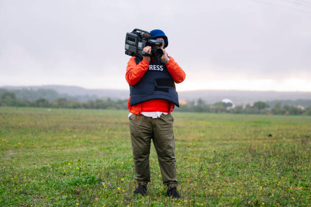 istock Reporter in bulletproof vest holding a video camera 2132421226