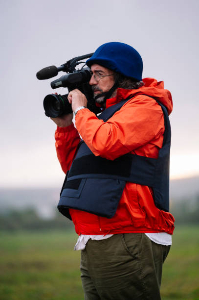 istock Reporter in bulletproof vest holding a video camera 2132421227