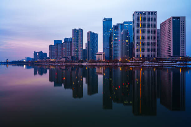 These skyscrapers are located in the Grand Canal Business District in Tongzhou District, Beijing, China. Situated along the canal, the skyscrapers are reflected on the river surface since the water is so calm in the morning.