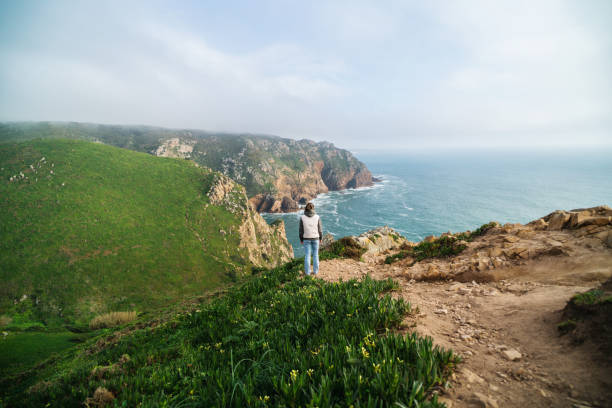Woman looking at the ocean view from a cliff