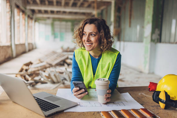 istock Smiling female construction worker planning on site 2132527261
