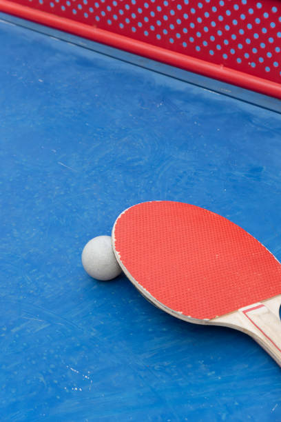 Ping-pong paddle and ball on white background