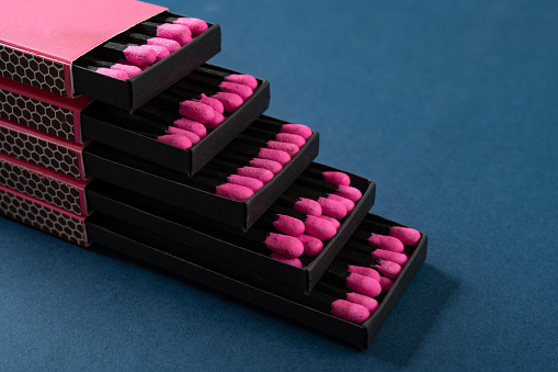 pink matchboxes stacks up on a blue background