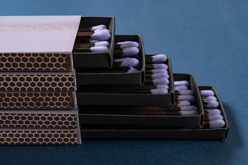 lilac matchboxes stacks up on a blue background