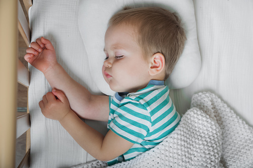 Toddler boy sleeping close-up on bed. Health care concept.