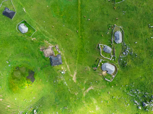 Photo of Aerial View of Mountain Cottages on Green Hill of Velika Planina Big Pasture Plateau, Alpine Meadow Landscape, Slovenia