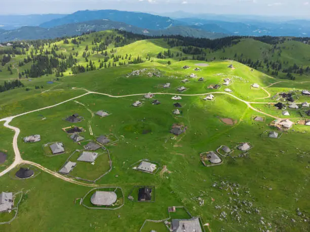 Photo of Aerial View of Mountain Cottages on Green Hill of Velika Planina Big Pasture Plateau, Alpine Meadow Landscape, Slovenia